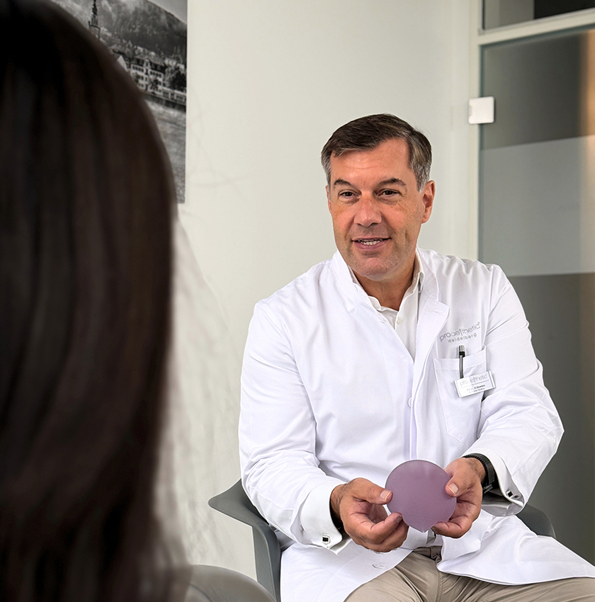Beratung zur Brustvergrößerung mit Implantaten – Priv.-Doz. Dr. med. Oliver Kloeters, proaesthetic Heidelberg Ein Arzt im weißen Kittel bei Proaesthetic während eines Beratungsgesprächs.